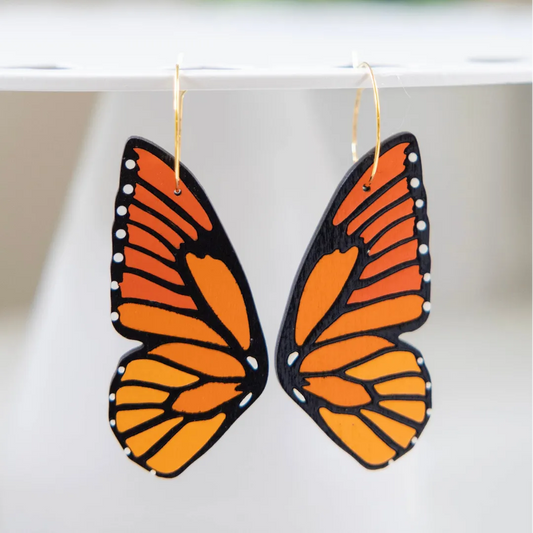 Hand-painted monarch butterfly wing hoop earrings in vibrant orange and black, made from lightweight wood.